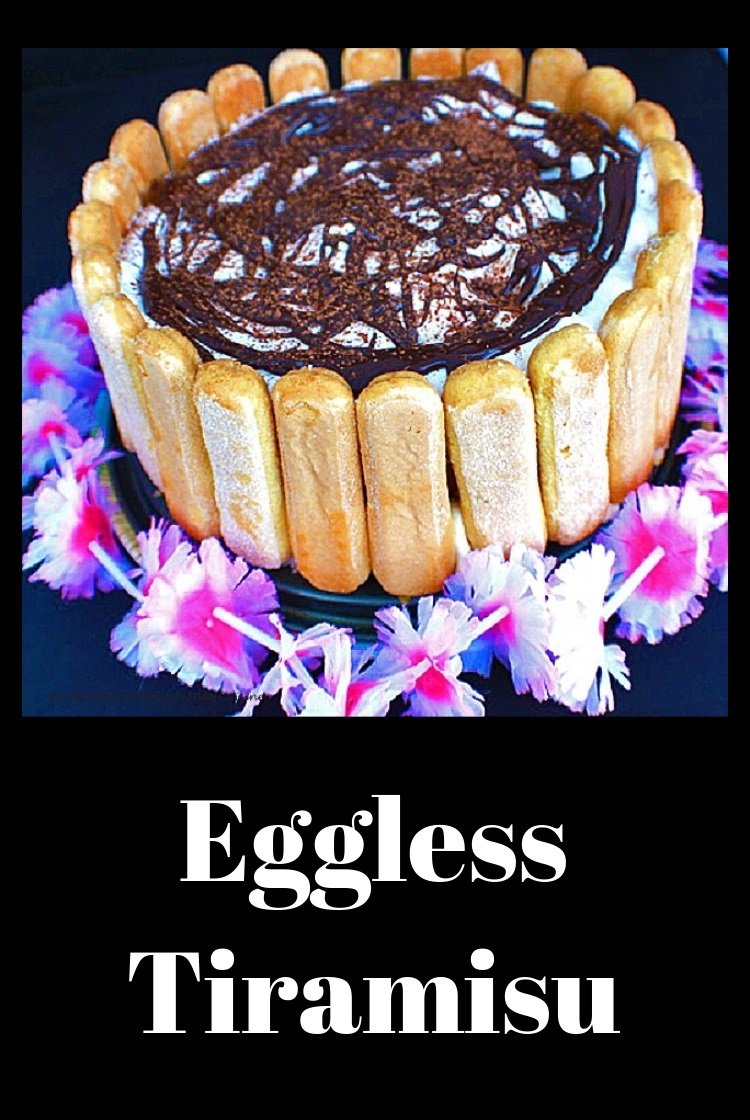 This is an eggless tiramisu with lady fingers, sponge cake a no bake filling topped with whipped cream, hot fudge and dusted with unsweetened cocoa powder