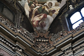 Detalle de una de las pechinas y una de las esquinas de la capilla, con decoración tipográfica, calaveras y huesos pequeños formando figuras.