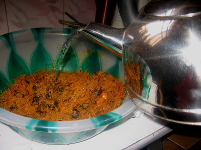 Adding boiling water to pounded palm nuts