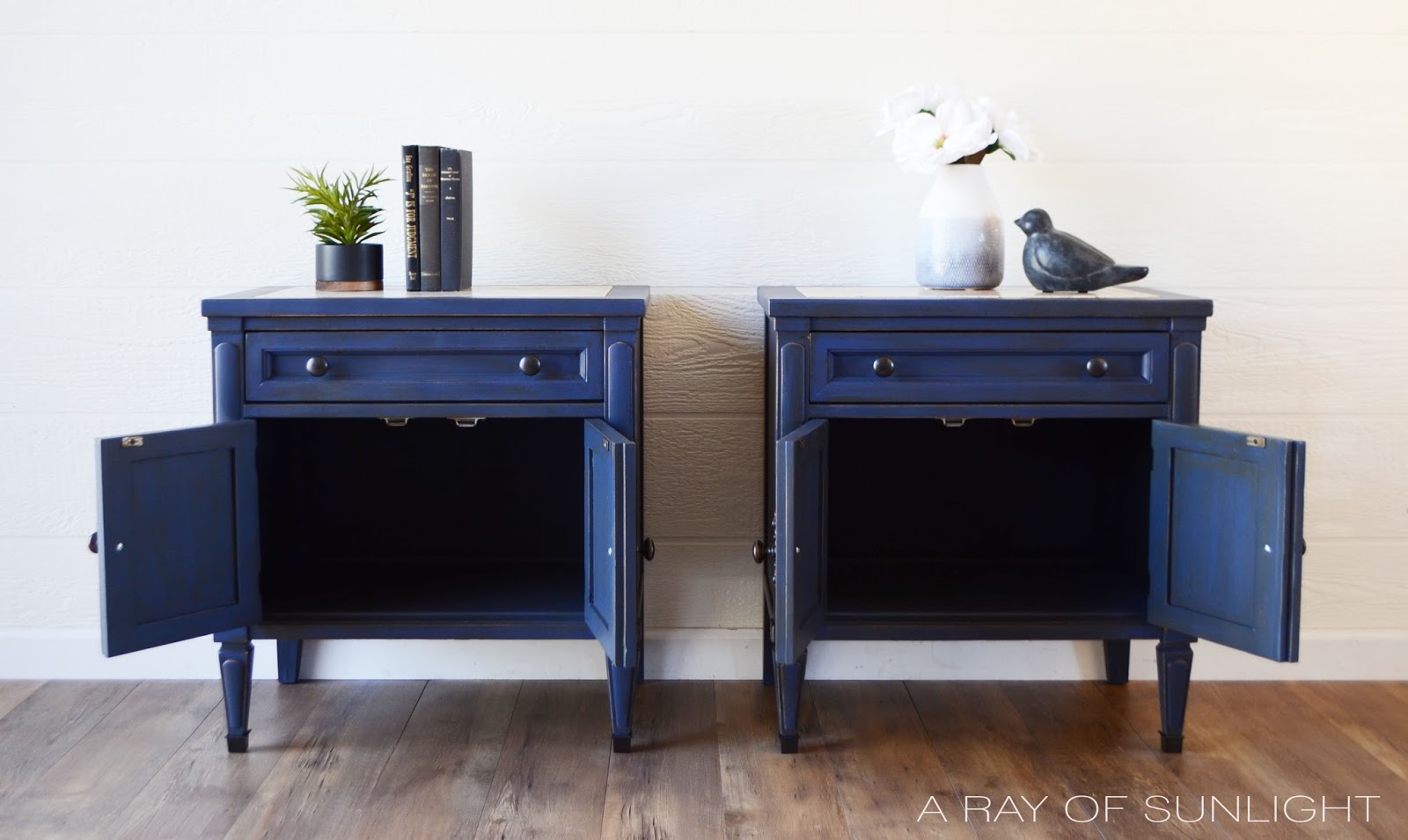 Blue painted and glazed nightstands with cabinet doors opened