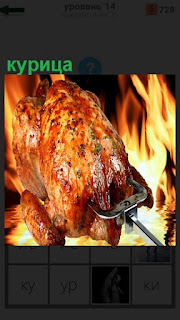 жарят  курицу на вертеле на большом огне, постепенно переворачивая