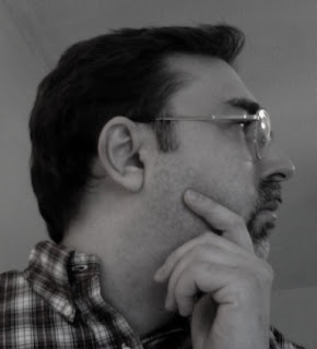 My profile pic.
... Get it?!? a portrait of the author in profile — male with dark hair, glasses, mustache and goatee, wearing a plaid shirt, hand resting on his chin as if in thought
