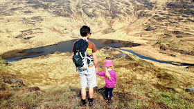 Postikorttimaisema, perhevaellus, vaeltaminen lasten kanssa, vaeltaminen Irlannissa, Irlanti, isä ja tytär, nummi, vuoristojärvi, marimekko