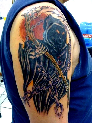 Grim Reaper tatuagem com um sorriso no rosto. Um mal rosto alegre ou sorriso é visto no reaper como ele realiza a sua foice de madeira e caçar mais almas.
