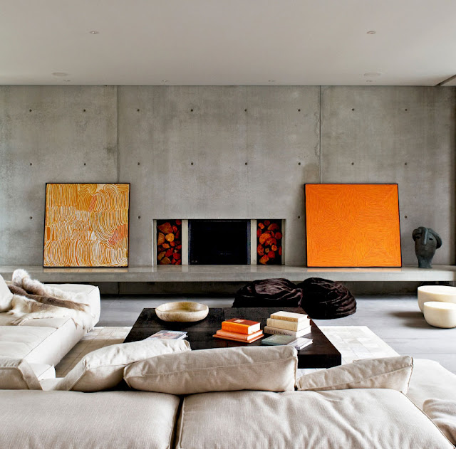 Modern living room with concrete wall and orange paintings