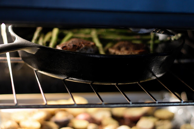 The pan with the chicken and asparagus being added to the oven to finish cooking.  