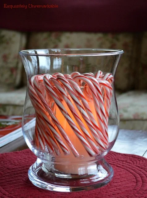 Christmas candy canes hanging on glass candle hurricane