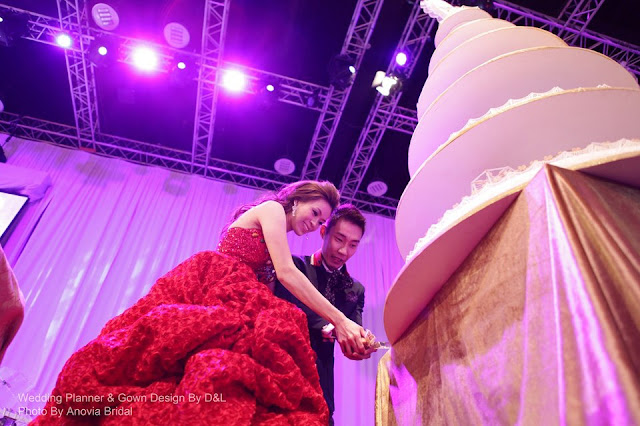MC was wearing a very elaborate dress, so long and heavy two girls had to help her carry the train up the stage for cake cutting.