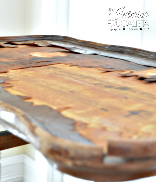An antique scalloped tilt-top table with very damaged wood veneer to be redeemed with a makeover.