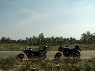 The rider's view mirror showing the road and the companion rider