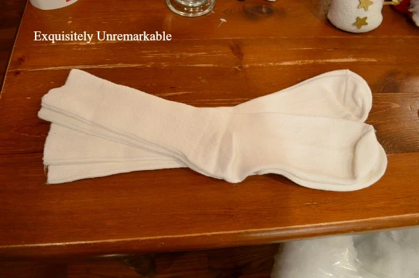 Two pairs of white athletic socks on a table