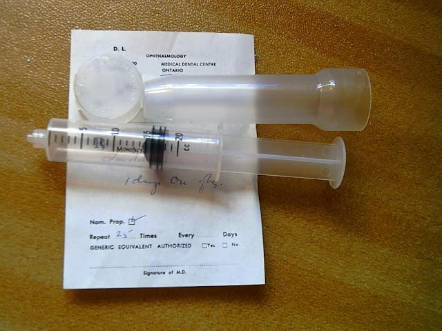 A prescription sheet partly covered by an empty syringe tube.