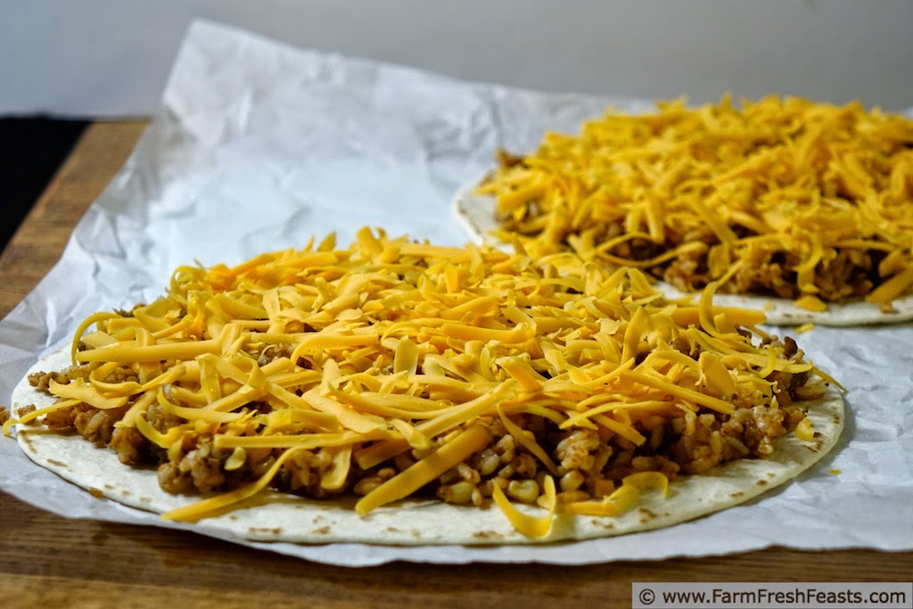 A easy and fast pizza for a family Pizza Night--combining leftover taco meat with vegetables and grains on a tortilla pizza covered with cheese.