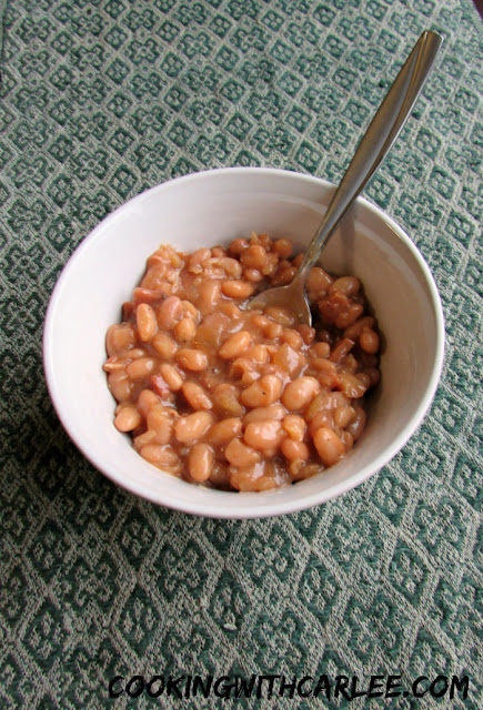 Delicious from scratch maple baked beans are a perfect side dish for your next bbq or potluck. Plus there are some great ideas from some of my friends. Burgers, sides, desserts and more! bowl of blond baked beans ready to eat
