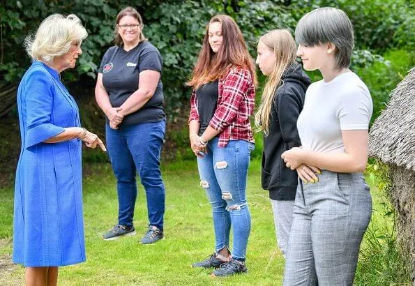 Duchess of Cornwall, Patron of Community First, visited Oxenwood Outdoor Education Centre. She wore a blue summer dress and pearl earrings