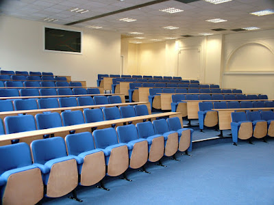university lecture theatre with blue upholstered seats with beech effect writing desks and co-ordinating seat bases