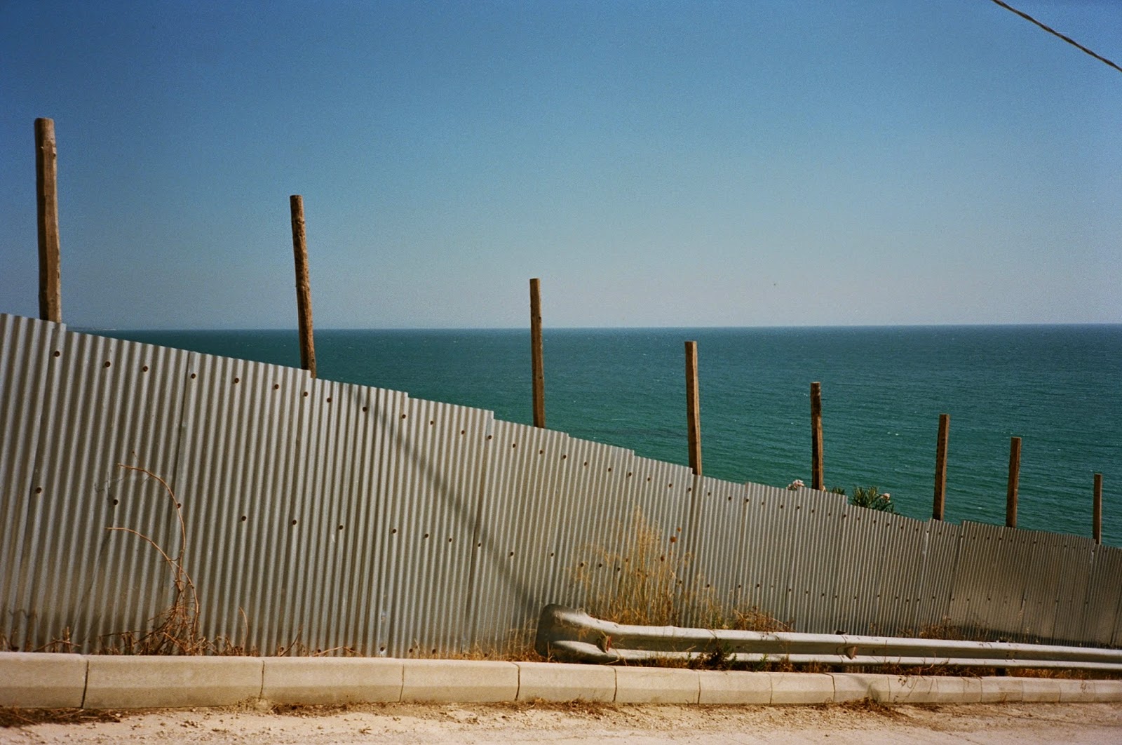 CORRUGATED SHEET METAL, BARACADE, DEVELOPMENT SITE, COASTAL VIEW IN SOUTHERN SICILY, AGRIGENTO, SCIACCA, SICILY © VAC 100 DAYS 4 MILLION CONVERSATIONS