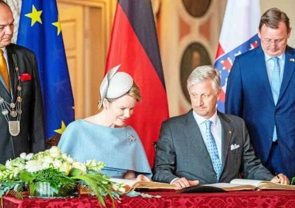 Queen Mathilde wore Natan grey cape dress. Thuringia and Saxony-Anhalt states of Germany. Erfurt-Weimar airport