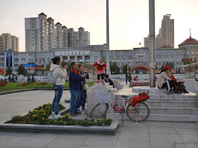 Adults clapping for a toddler singing and dancing at Culture Square in Mudanjiang, China