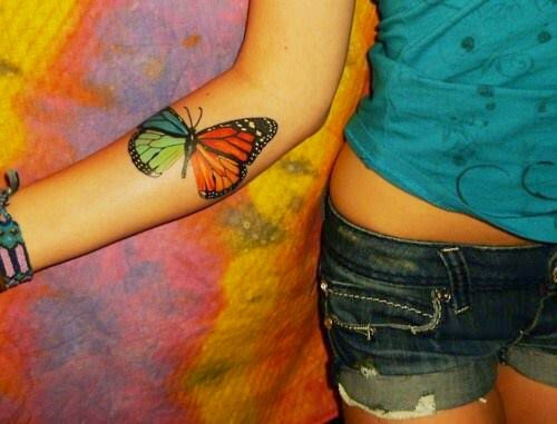 chica con un tatuaje de mariposa en el antebrazo