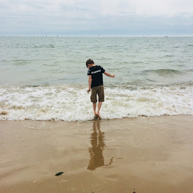 Kids with autism can find some things difficult.  An autistic boy tries to walk in the water at a beach.