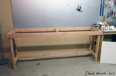 wood 2x4s bench and peg board on wall to hold tools