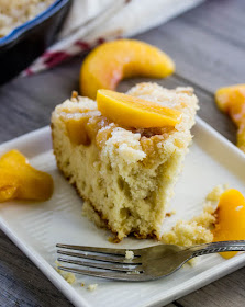 Use fresh or frozen peaches to make all of tour breakfast dreams come true. This cake is perfect for tea time too. It's an old fashioned recipe that will quickly become a an all time favorite. slice of peach breakfast cake with bite missing
