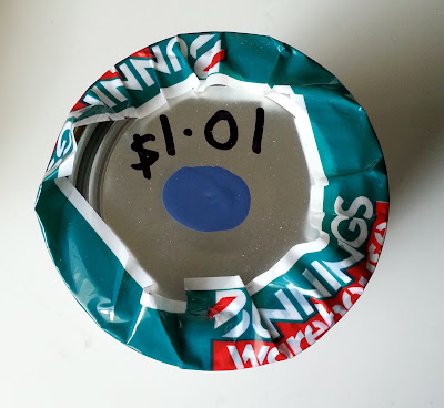 Top of a test pot of paint, showing a dab of blue paint and the price ($1.01) written on it.