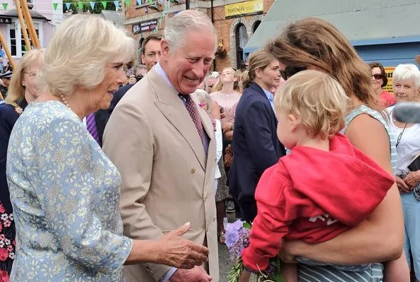 The Duchess of Cornwall wears a pale blue floral midi dress for the visit. Prince Charles