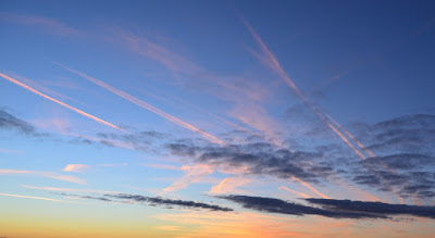 Foto: blauer Himmel mit rosa schimmernden Wolkenfetzen