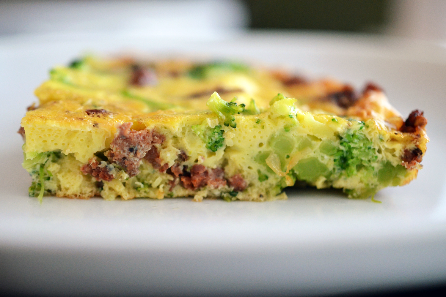 A slice of paleo and Whole30 easy paleo frittata with bacon and broccoli.