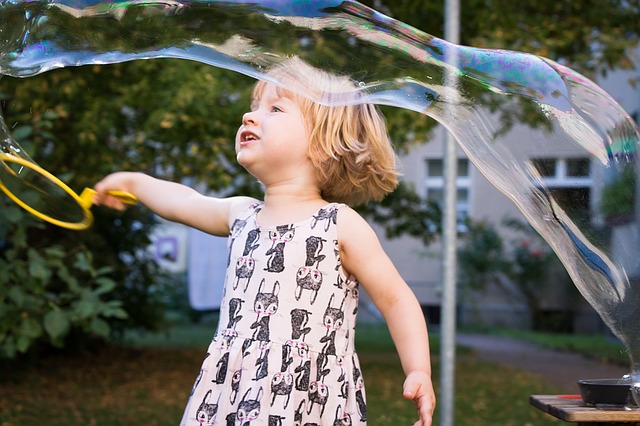 Kind spielt mit Seifenblasen