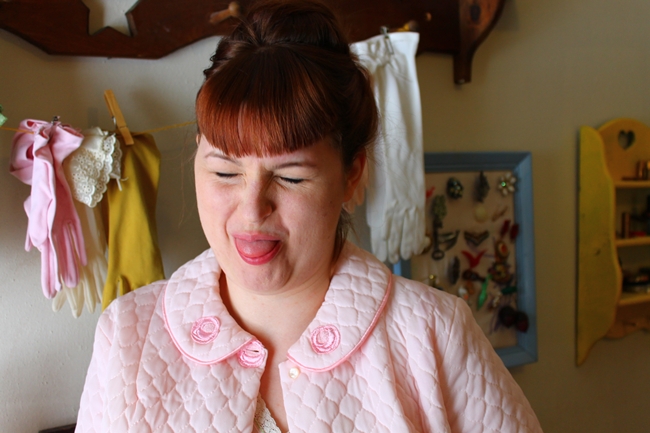 Brittany with new bags, making a silly face in pink vintage bed jacket