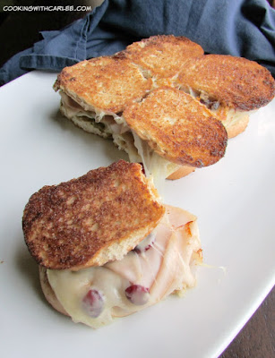 What is better than a grilled cheese? Not much! These sliders are snack size, butter, golden, cheesy and have pesto, dried cranberries, turkey and plenty of gooey cheese! a turkey cranberry pesto and cheese slider pulled apart from the rest