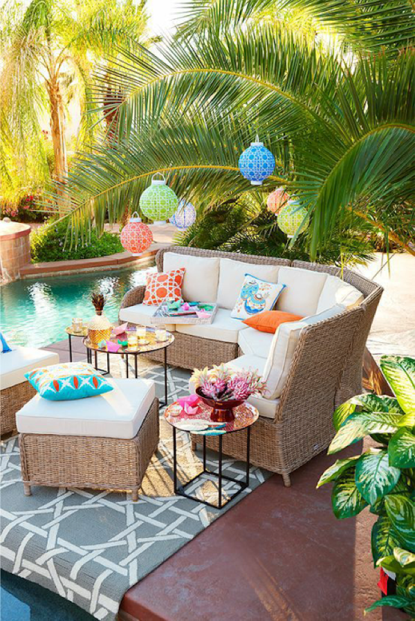 Colorful lanterns, tropical plants, a beautiful pool,  and pretty pops of color make this outdoor space the perfect staycation spot. 