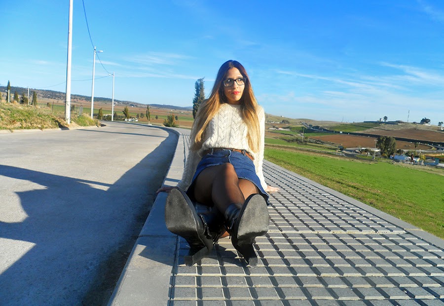 Falda denim acamapanda, jersey de punto rasgado, cazadora biker negra y botines de tacón con hebillas