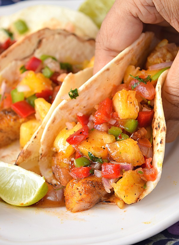 A close up of easy best fish taco with honey chili sauce and pineapple jalapeno salsa