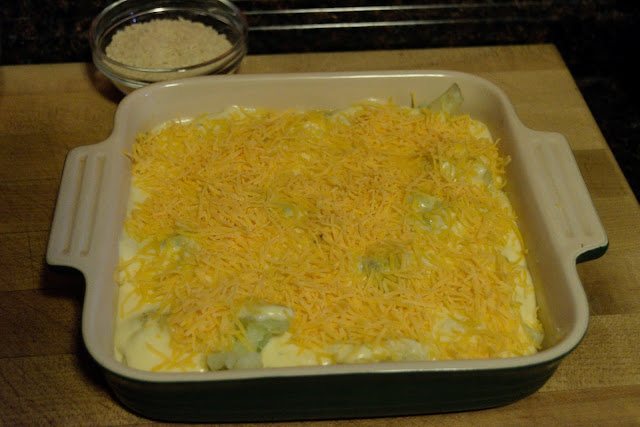 Shredded cheese being added to the baking dish. 