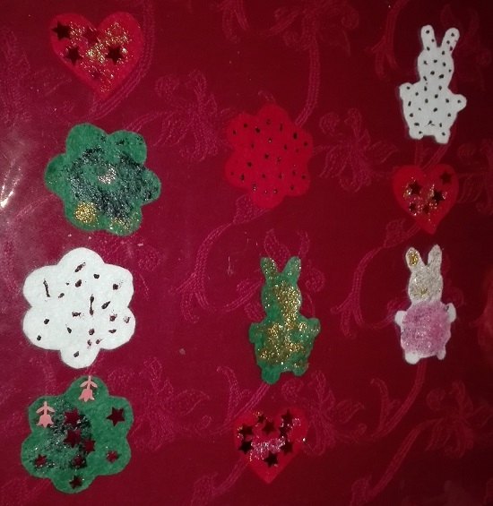 Huopakoristeet odottavat ketjuun laittamista. askartele joulukoriste huovasta