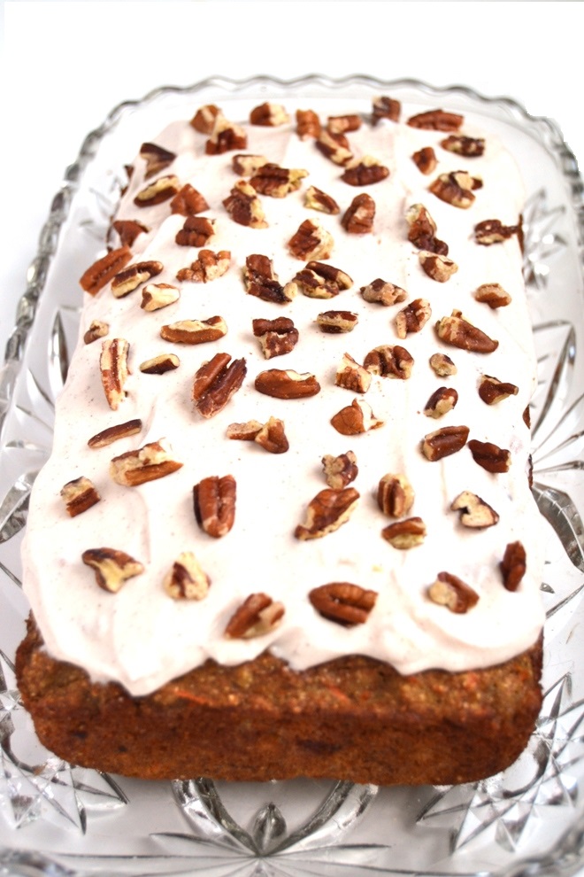 Carrot Cake Banana Bread with Cream Cheese Frosting is a moist and healthy treat that tastes like cake made with whole-wheat flour and apple sauce. It is topped with cinnamon cream cheese Greek yogurt frosting- you won't be able to stop at one slice! www.nutritionistreviews.com