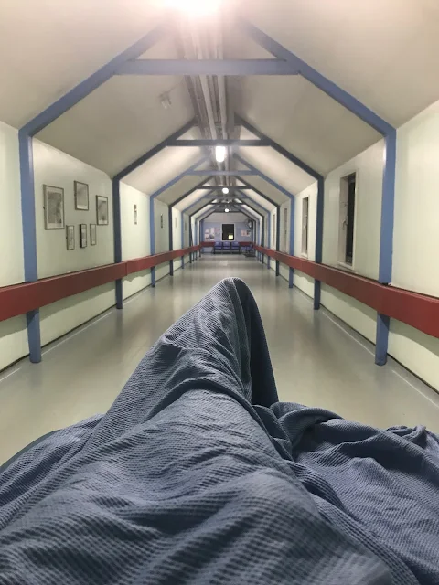 A view from a hospital trolley being wheeled down a long hospital corridor