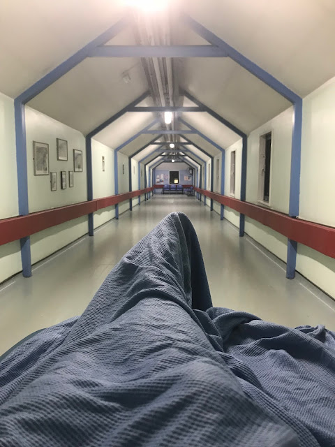 A view from a hospital trolley being wheeled down a long hospital corridor