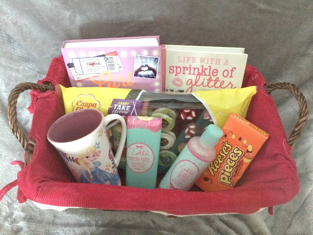 gift basket filled with toiletries, sweets, book, mug 
