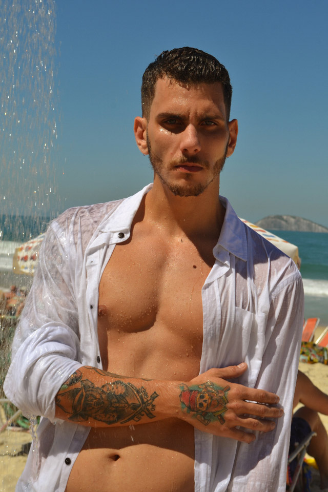 Lucas Monteiro, candidato a Mister Caxias 2017, toma banho de chuveirinho durante ensaio em praia do Rio. Foto: Sidney Boock