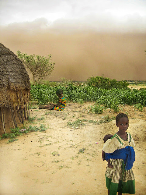 Unos niños africanos en un entorno árido.