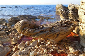 Balancing Triangular stone and red iron-rich clay along the sea north of Umag, Croatia