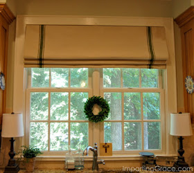 Paint a dropcloth to resemble a grainsack and create a faux Roman shade with tension rods