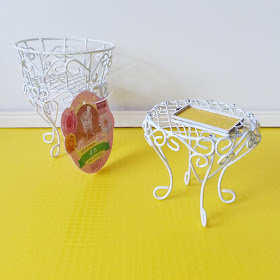 White wire flower pot holder with a one-twelfth scale miniature white wire side table next to it, holding a yellow and white tray.