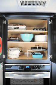 Organized cupboard for trays and serving dishes above double oven :: OrganizingMadeFun.com