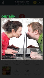 Около ноутбуков мужчина и женщина онлайн целуют друг друга